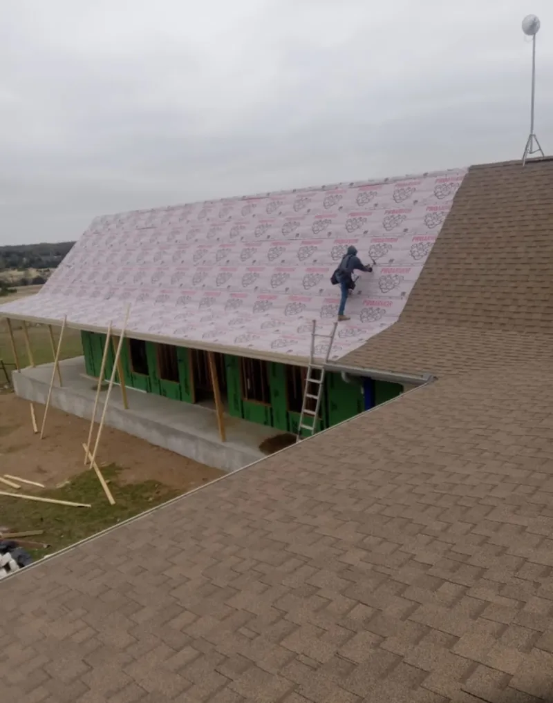Worker preparing underlayment for a metal roof installation in Medical Lake